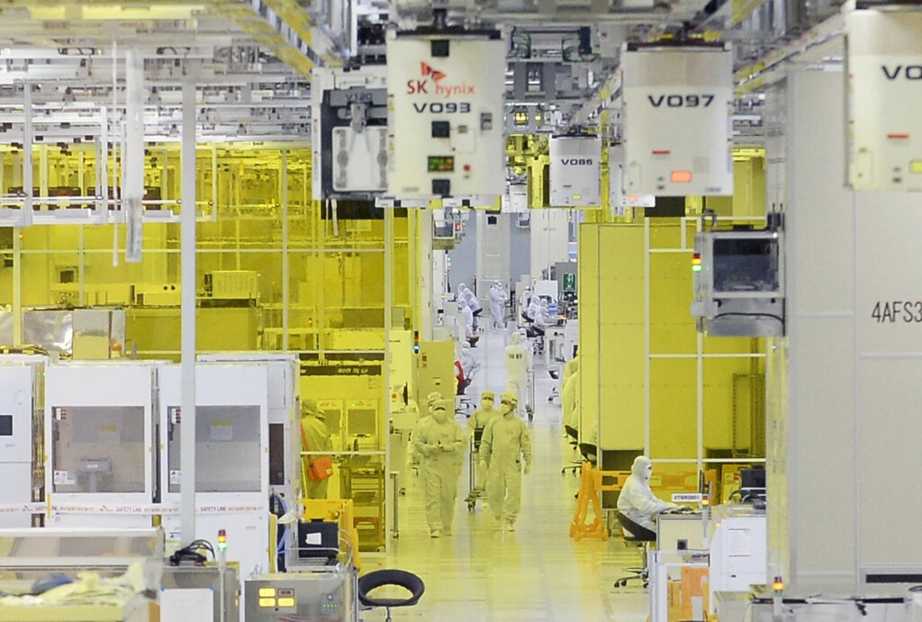 Workers are seen on the operations floor of an SK Hynix plant in Icheon on August 25, 2015. South Korea's SK Hynix Inc., the world's second-largest memory chip maker, announced August 25 it would spend 46 trillion won (US$38 billion) in facility investments over the next 10 years. AFP PHOTO/POOL/KIM MIN-HEE (Photo by KIM MIN-HEE/POOL/AFP).